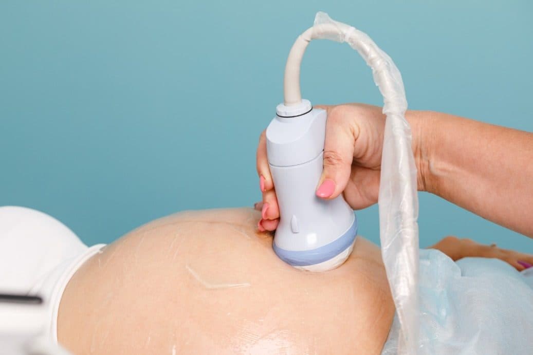 Ultrasound probe resting on a pregnant belly